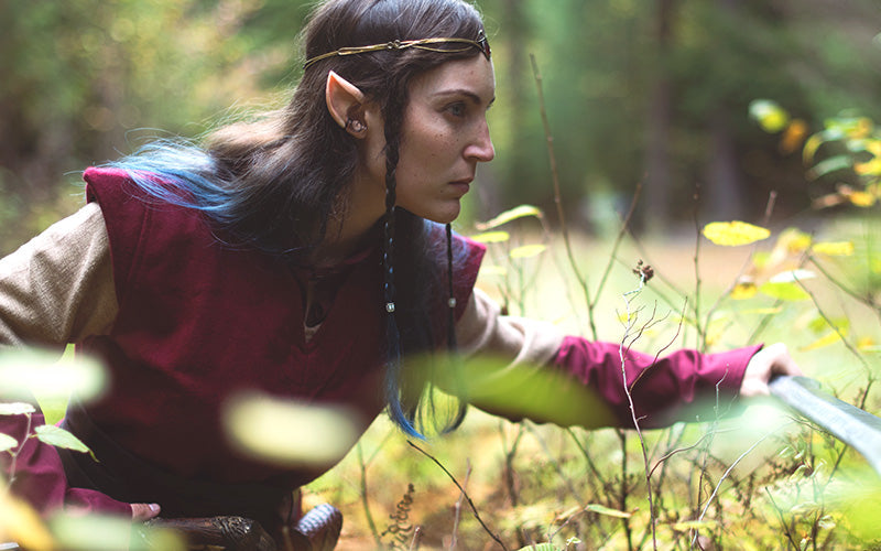 women in an elf fantasy costume in the nature