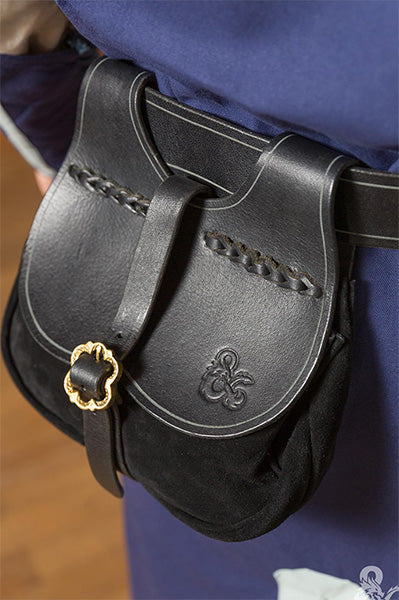Black leather pouch with gold clasp on a person wearing a blue garment.
