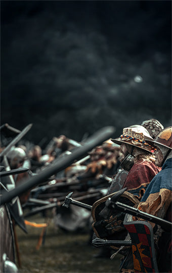 Medieval warriors with spears in a dark, smoky larp battlefield