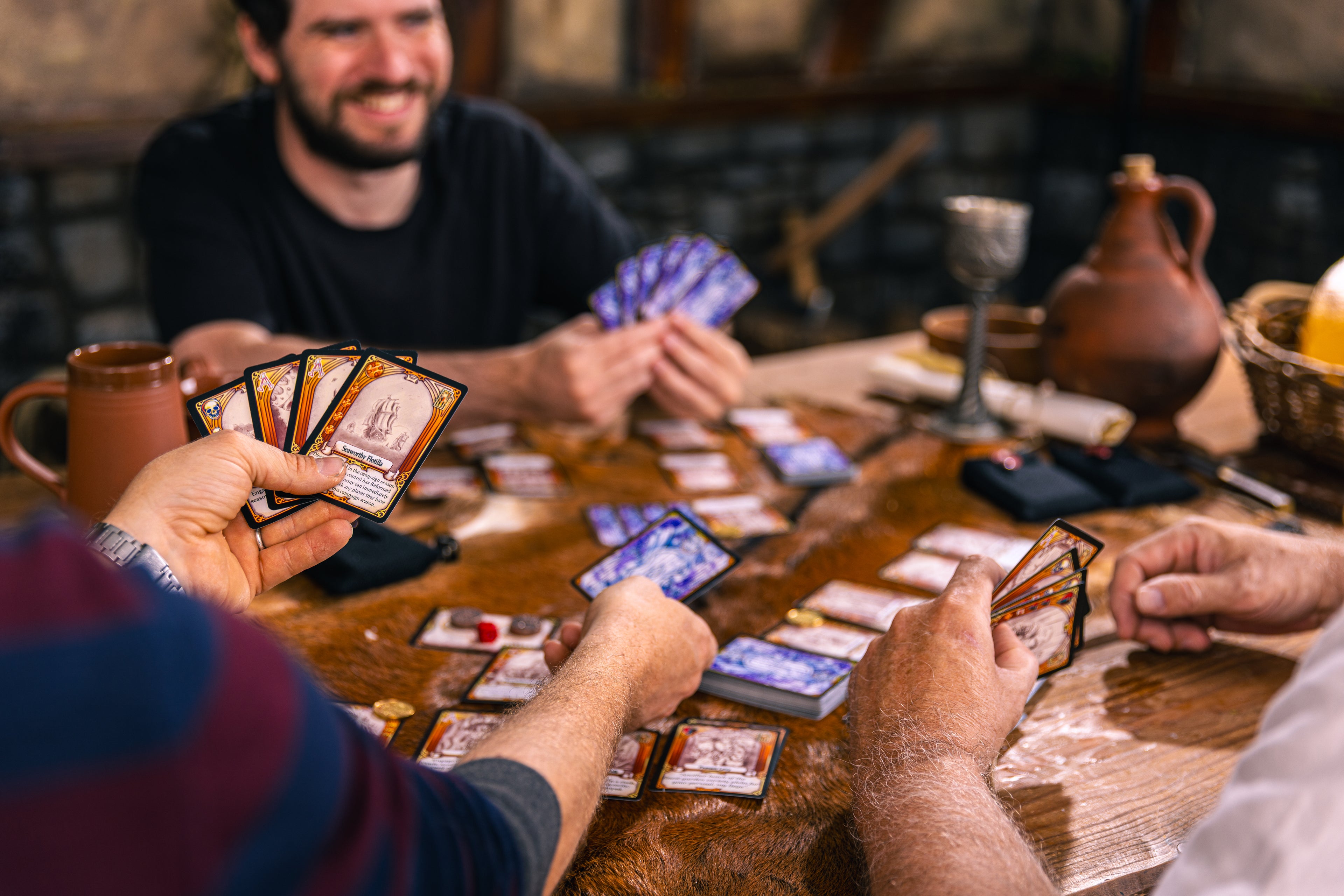People playing card games around a table in a cozy setting
