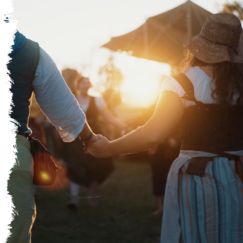 Two people holding hands with a sunset in the background