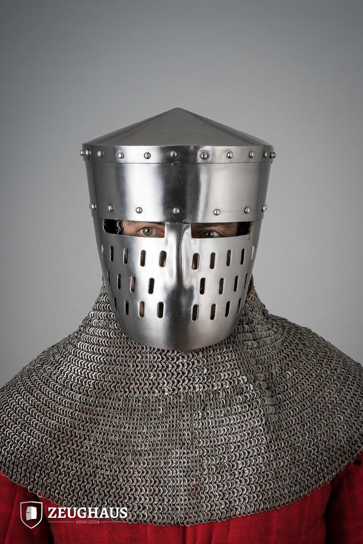 Person wearing a chainmail coif and metal medieval helmet on a gray background