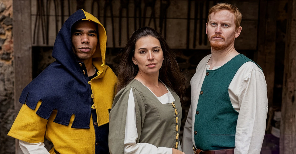 Three people in historical medieval costumes standing together against a rustic background