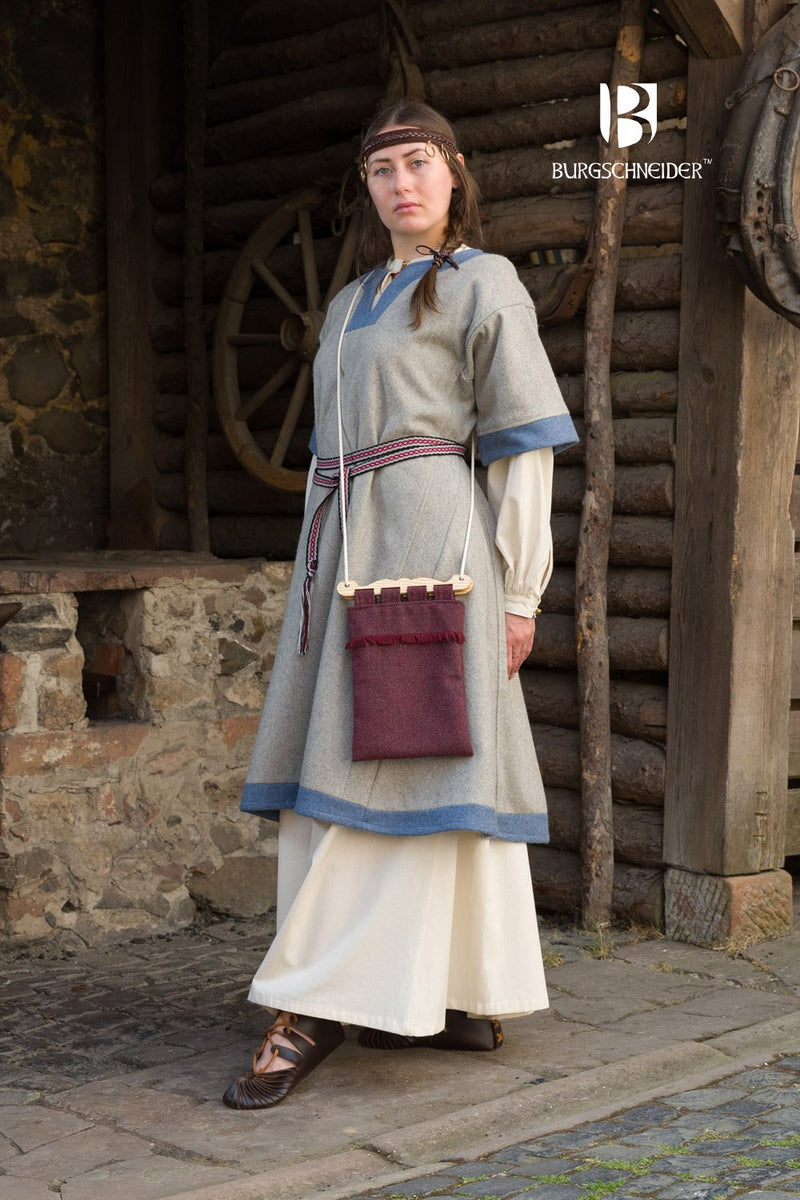 Women wearing a medieval dress outfit standing in front of a stone building