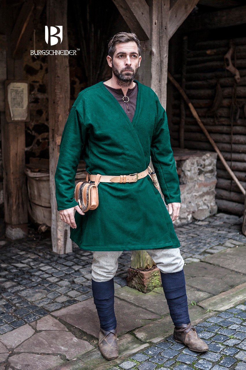 Man in green medieval tunic and blue stockings standing in a rustic setting with 'Burgschneider' branding.