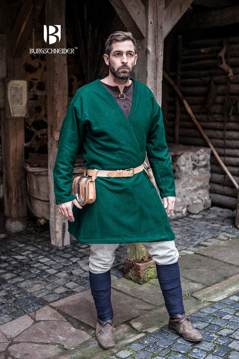 Man in green medieval tunic and blue stockings standing in a rustic setting with 'Burgschneider' branding.